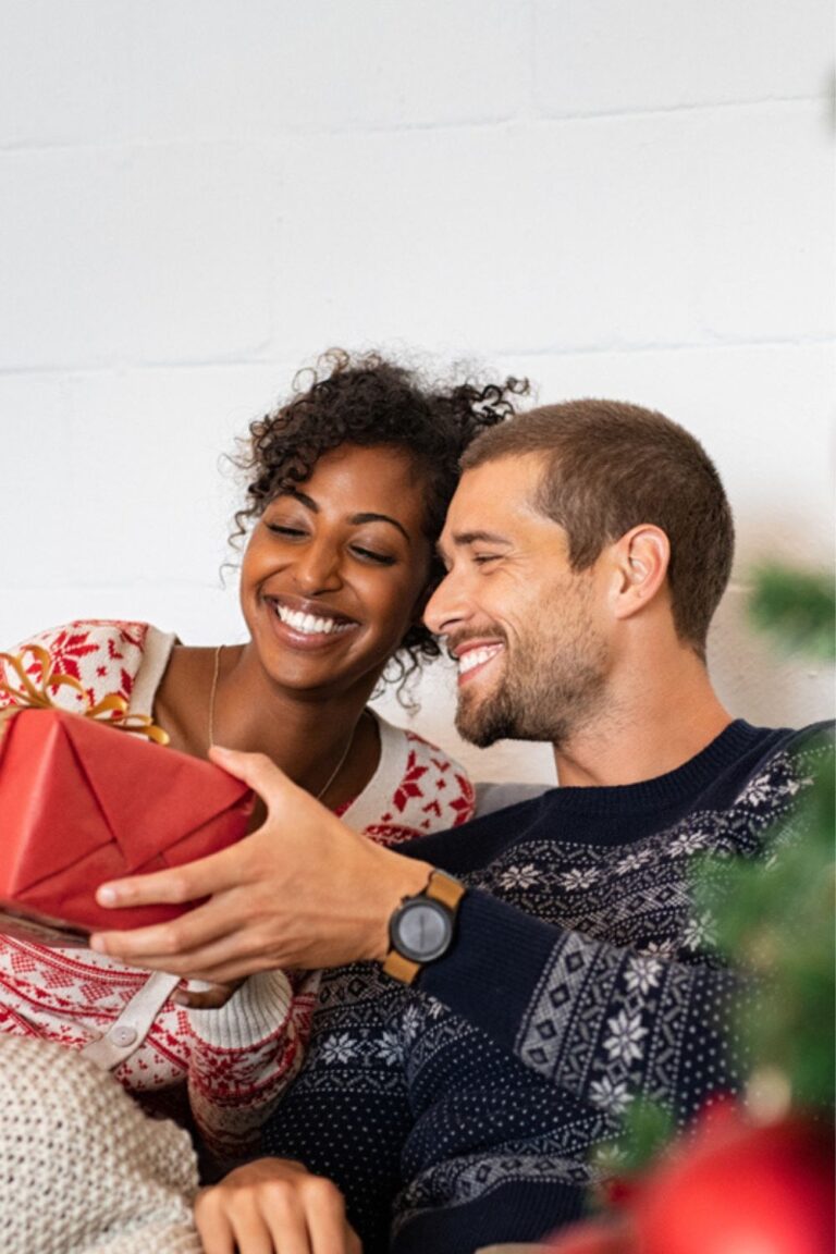 woman giving her boyfriend a Christmas gift